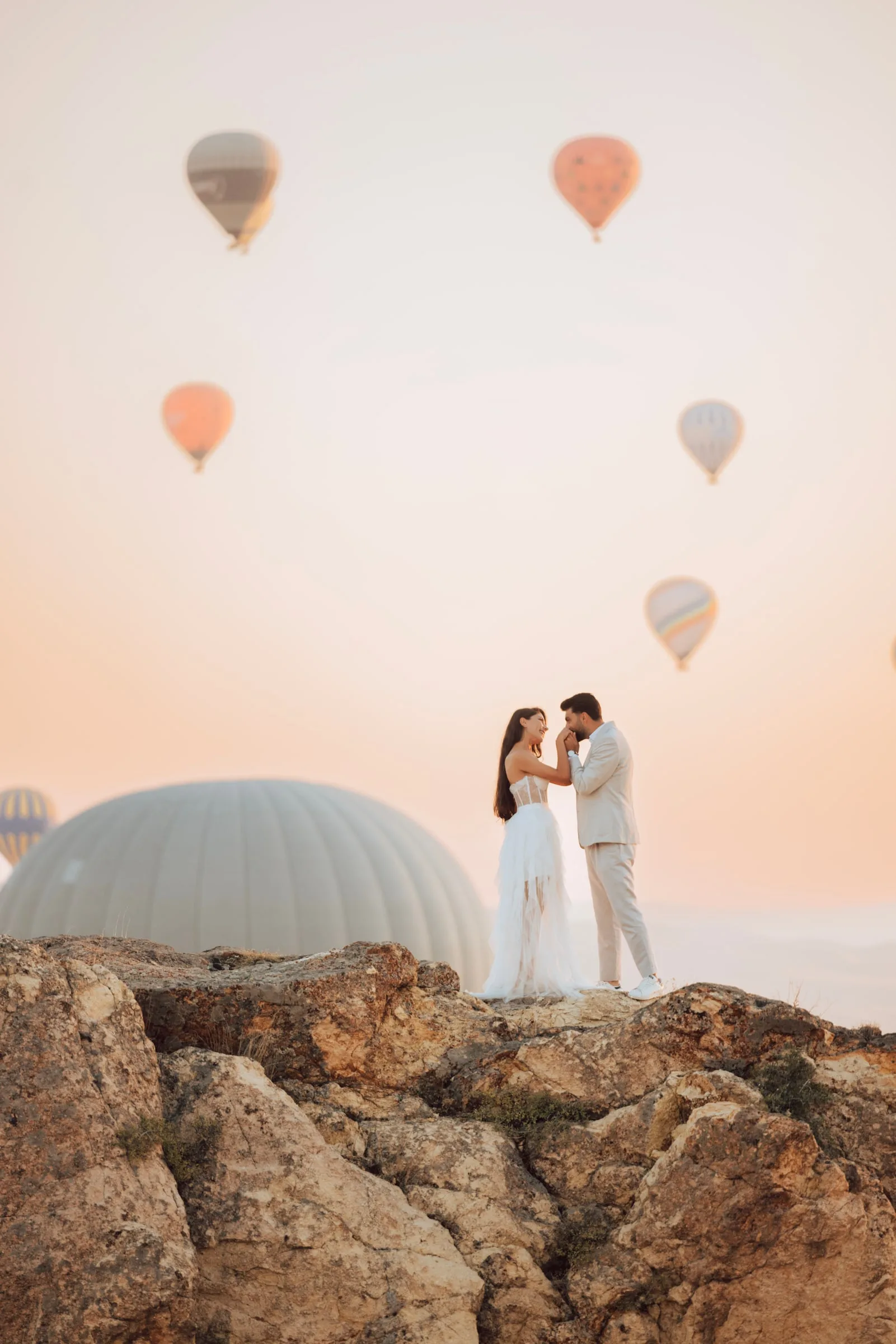 Kayalıklarda gündoğumu, balonlar altında gelin ve damat